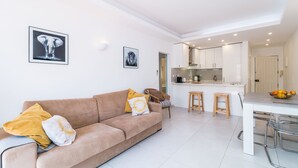 Un salon moderne comprenant un canapé, une table à manger et un coin cuisine.