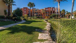 Un hôtel doté d’une cour intérieure, de palmiers et d’un chemin pavé.