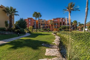 Ein Hotel mit Innenhof, Palmen und einem gepflasterten Weg.
