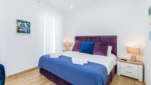 Una camera da letto moderna con un letto, comodini e un quadro appeso alla parete.