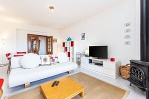 A modern living room with a sofa, coffee table, TV, and a fireplace. - Lagos Sea View | Near the City Center (Lagos)
