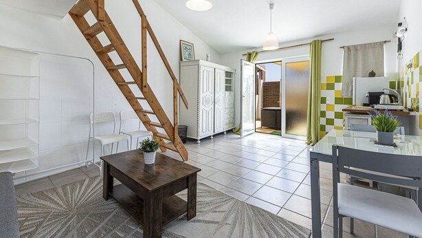 A modern kitchen with a dining area, a staircase, and a view into the dining room. - Chilling Studio in Lagos (Lagos)
