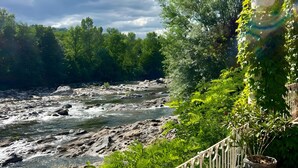 Une vue sur la rivière, avec un chemin bordé de briques et une rambarde blanche.