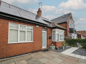 A residential house with a brick facade, a tiled roof, and a small front garden with stepping stones. - Mount Joy (Leicester)