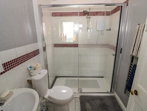 A bathroom with a toilet, bidet, and glass-enclosed shower stall. - Mount Joy (Leicester)