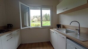 A kitchen with a window, a sink, and a coffee maker.
