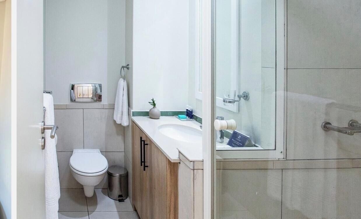 Une salle de bain moderne équipée de toilettes, d’un lavabo et d’une douche.