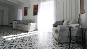 Una sala de estar con dos sofás, una mesa de centro y suelo estampado.