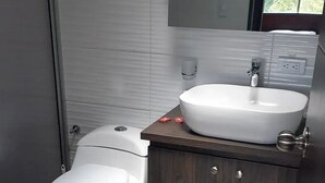 Ein modernes Badezimmer mit Toilette, Waschbecken und Schrank.