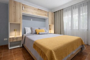 Una camera da letto con un letto, comodini, un armadio e una finestra con tende.