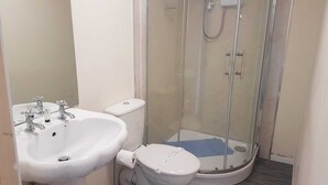 Ein Badezimmer mit Waschbecken, Toilette und einer Duschkabine.