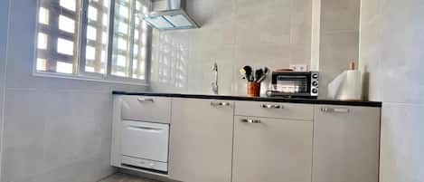 A kitchen with a built-in oven, a microwave, and a sink.