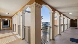 Ein Korridor mit Säulen, Geländern und Blick auf Gebäude.