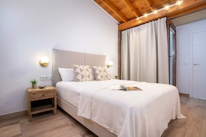 Ein Schlafzimmer mit Bett, Nachttisch, Wandleuchten und einer Tür.