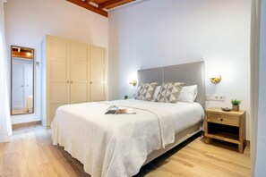 Ein Schlafzimmer mit Bett, Nachttisch, Kleiderschrank und Spiegel.