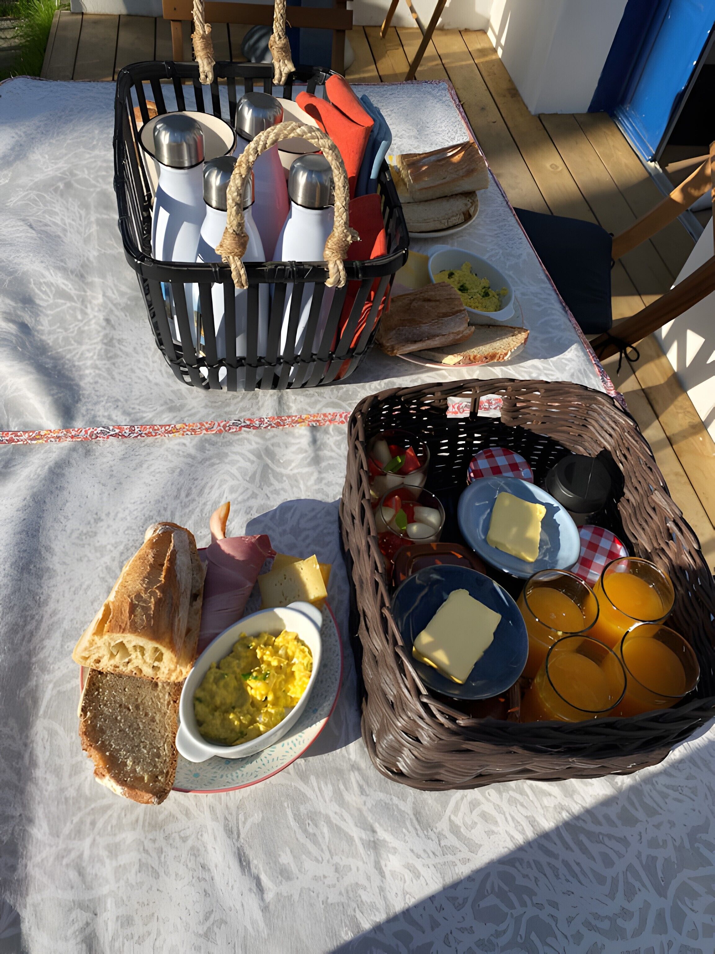 A picnic setup with bread, cheese, and drinks on a table.