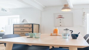 A modern kitchen with a wooden table, black chairs, a coffee machine, and a juice dispenser. - House in Porspoder by Plage du Bourg Beach (Porspoder)