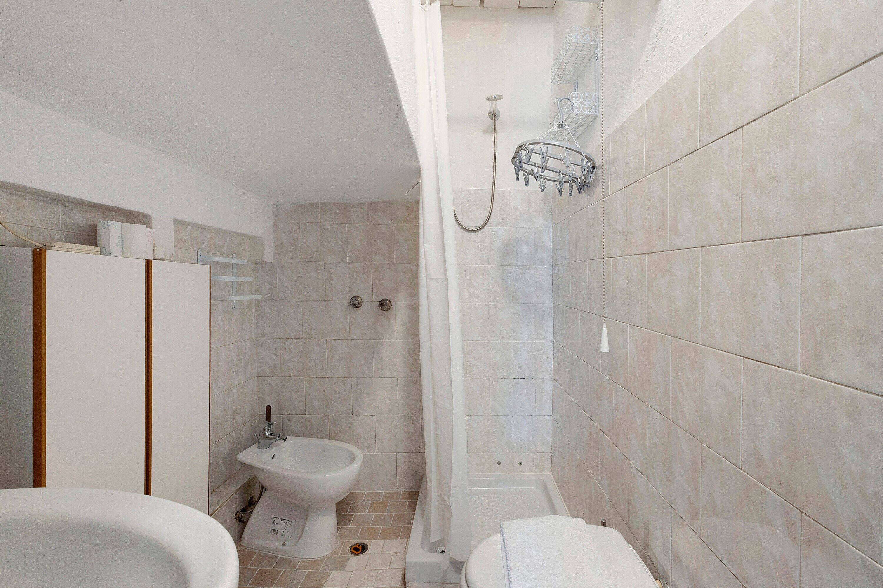 Une salle de bain équipée d’une douche, de toilettes, d’un bidet et d’une baignoire.