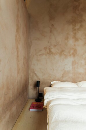 A room with a bed, a nightstand, a lamp, and a book. - Light apartment with rooftop views in Tøyen (Oslo)