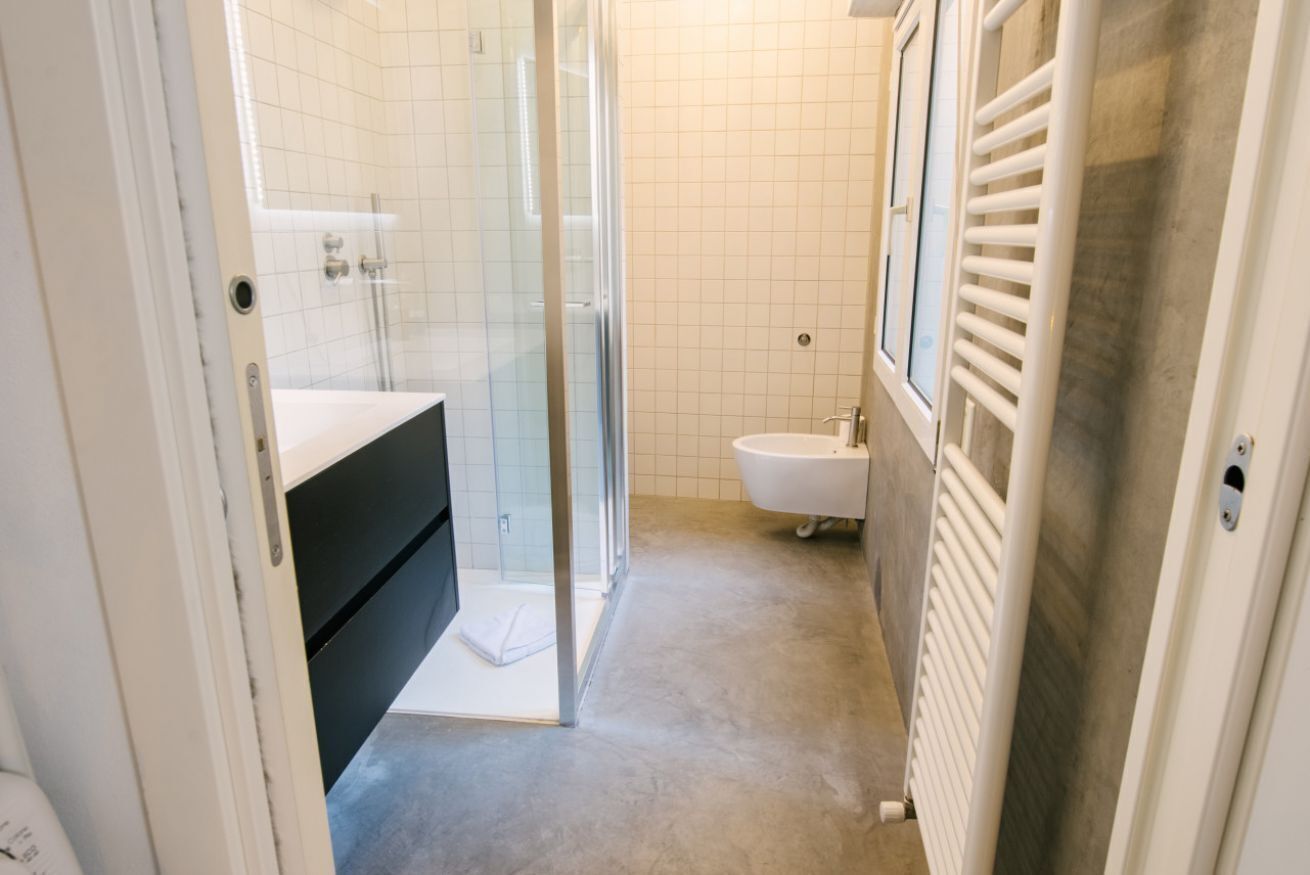 A bathroom with a glass shower enclosure, a white sink, and a bathtub.
