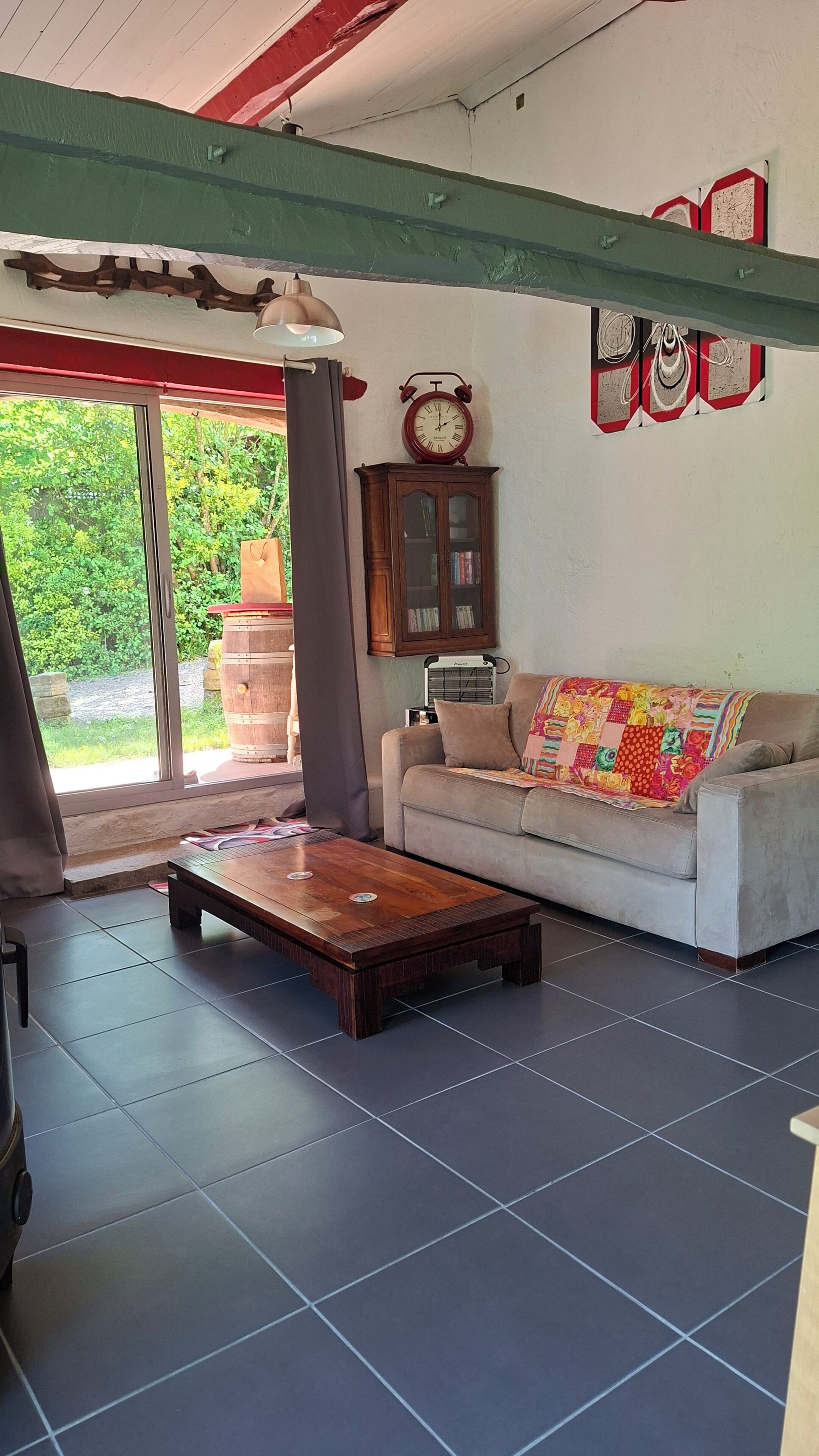 A living room with a sofa, a wooden coffee table, a cabinet, and a clock on the wall.