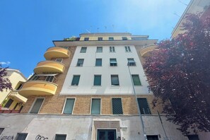 A multi-story building with balconies, a flat facade, and a clear sky. - 4BNB - DAquino Apartment close to Vatican Museums (Rome)