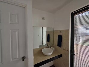 A bathroom with a white sink, a mirror, and a towel rack. - Just 15 minutes from Antigua Guatemala, within the La Joya Condominium. (Santa Lucía Milpas Altas)