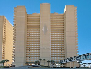 A high-rise hotel with multiple balconies and a central vertical design element. - Ocean Villa 406 (Panama City Beach)