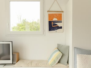 A room with a bed, a window, a framed picture, and a television. - Charming Coastal Home in Landunvez (Landunvez)