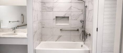 Un bagno moderno con una vasca, una doccia e un mobile lavabo.