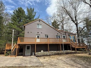 Ein zweistöckiges Haus mit Veranda und kleiner Terrasse.