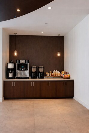 Una cocina moderna con electrodomésticos integrados, una zona de café y una despensa.