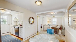A spacious living area with a kitchen, a dining table, and a sofa. - Rehoboth Beach Gem - New bathrooms, porch, washer & dryer walk to beach (Rehoboth Beach)