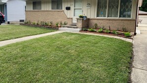 A single-story house with a front porch, a mailbox, and a small garden.