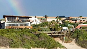 Una proprietà fronte spiaggia con un pontile di legno, una spiaggia e vista sull'oceano.