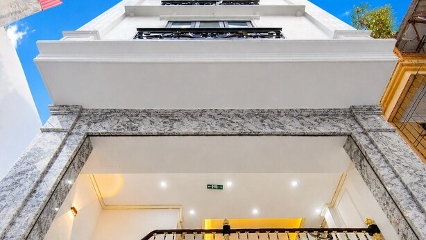 A multi-level hotel interior with a staircase, marble flooring, and a balcony with railings. - Quang Huy Hotel - Trung Phung (Hanoi)