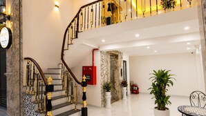 A grand staircase with ornate railings and a red fire alarm box. - Quang Huy Hotel - Trung Phung (Hanoi)