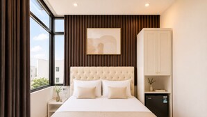 A hotel room with a large bed, a wardrobe, a nightstand, and a window with curtains. - Quang Huy Hotel - Trung Phung (Hanoi)