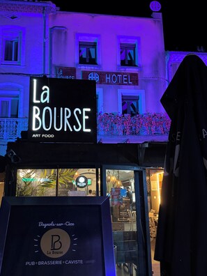 Un edificio con un letrero que dice 'La Bourse Art Food' y 'AHH HOTEL'.