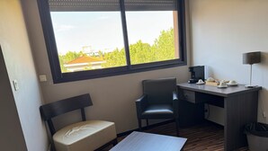 Ein kleiner, moderner Raum mit Schreibtisch, Stuhl und Bank.