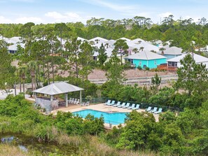 Un complexe hôtelier doté d’une piscine, de chaises longues et d’un espace abrité.