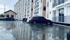 A multi-story residential building with a brick-paved parking area. - Kawe beach Apartments, get a clear city view of Dar es Salaam from your balcony (Dar es Salaam)