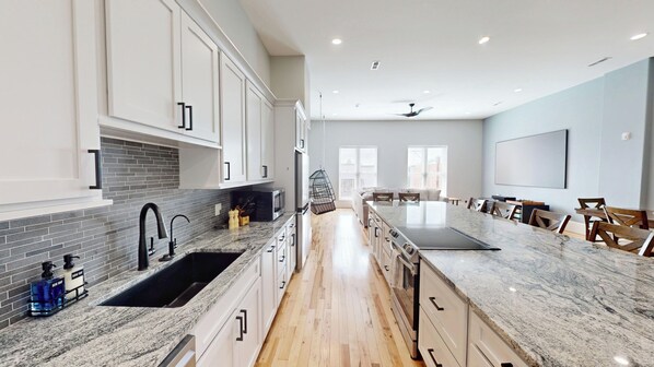 A modern kitchen with granite countertops, white cabinetry, and a central island.