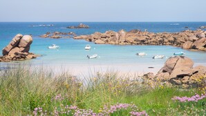 A coastal landscape with rocky formations, clear blue water, and boats. - Holiday Home by Lampaul Beach With Garden (Lampaul-Ploudalmézeau)
