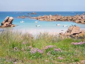 Eine Küstenlandschaft mit Felsformationen, klarem, blauem Wasser und Booten.