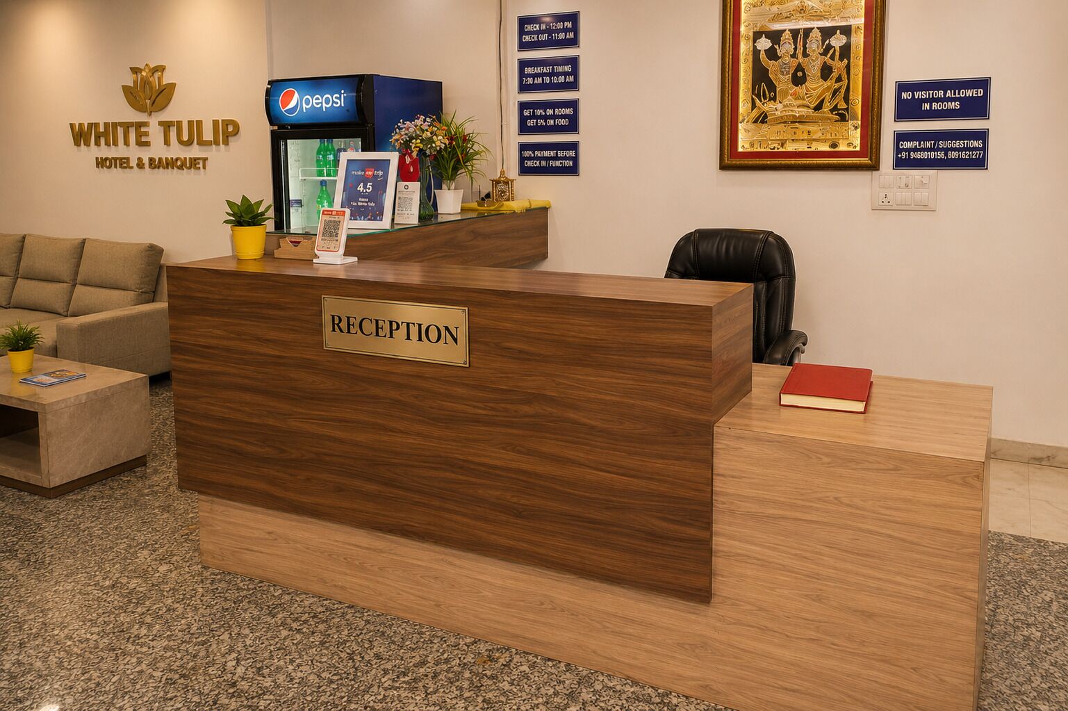 A reception desk with a 'RECEPTION' sign, a Pepsi refrigerator, a framed deity image, and a 'NO VISITOR ALLOWED IN ROOMS' sign.