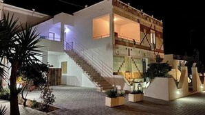 A two-story building with a staircase, outdoor lighting, and planters. - Aqua Home Area – Aqua Ground (Porto Cesareo)
