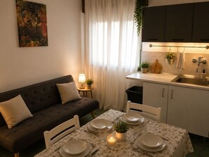 Eine moderne Küche mit Essbereich, einer Couch und einem Bild an der Wand.