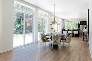 A spacious dining area with a large table, chairs, and a chandelier. - Emerald Acres, an elevated Retreat on Five Private Acres (Bellingham)