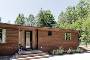 A modern wooden house with a front door, steps, and a small window. - Emerald Acres, an elevated Retreat on Five Private Acres (Bellingham)